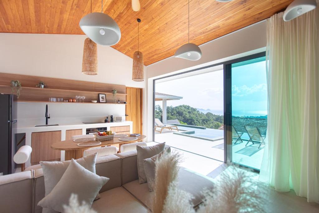 a living room with a couch and a table at Siam Mila Villas in Srithanu