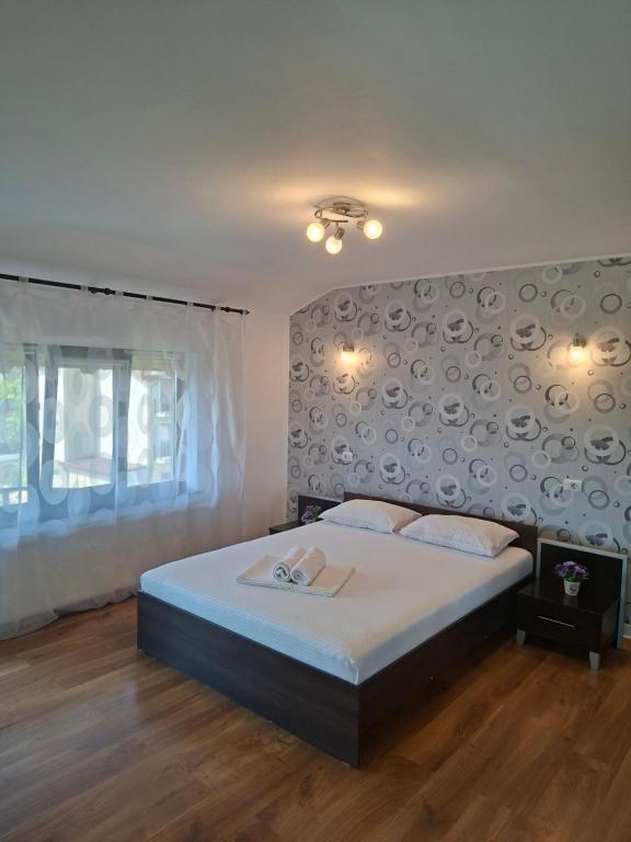 a bedroom with a large bed with a large wall at Pensiunea Turist in Techirghiol
