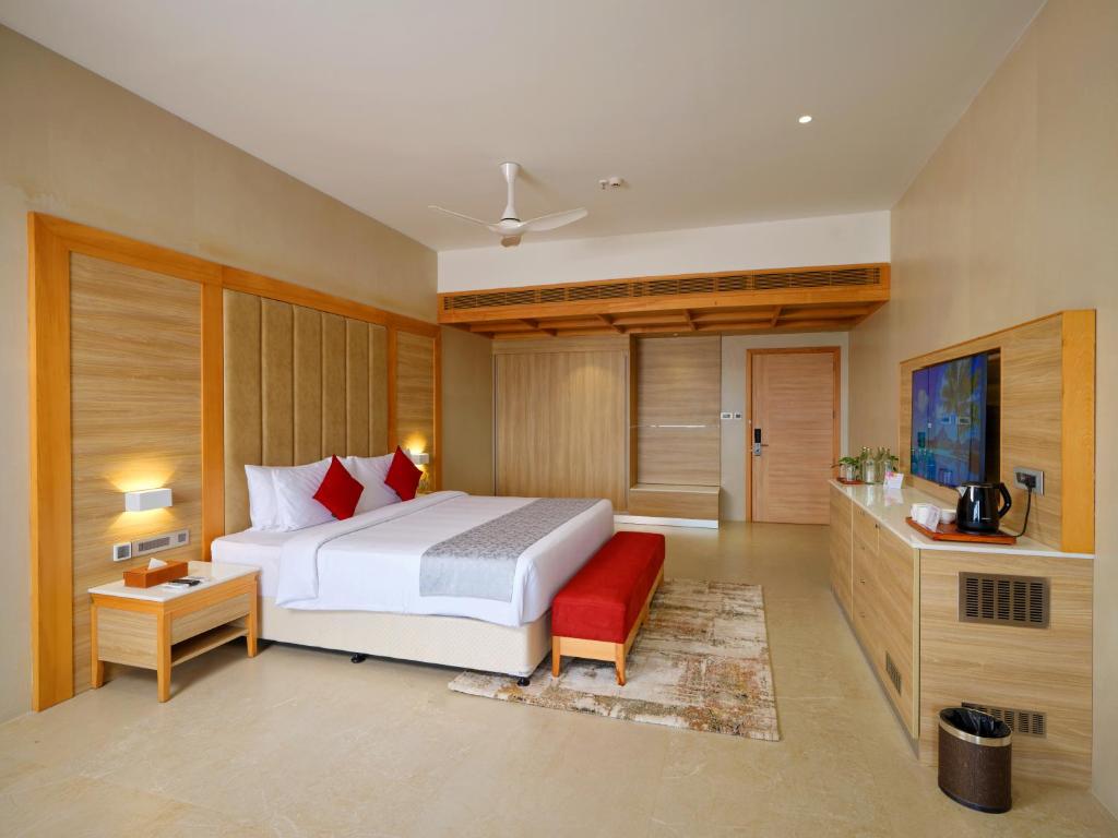 a bedroom with a white bed and a red couch at Vibe Munnar Resort & Spa in Munnar