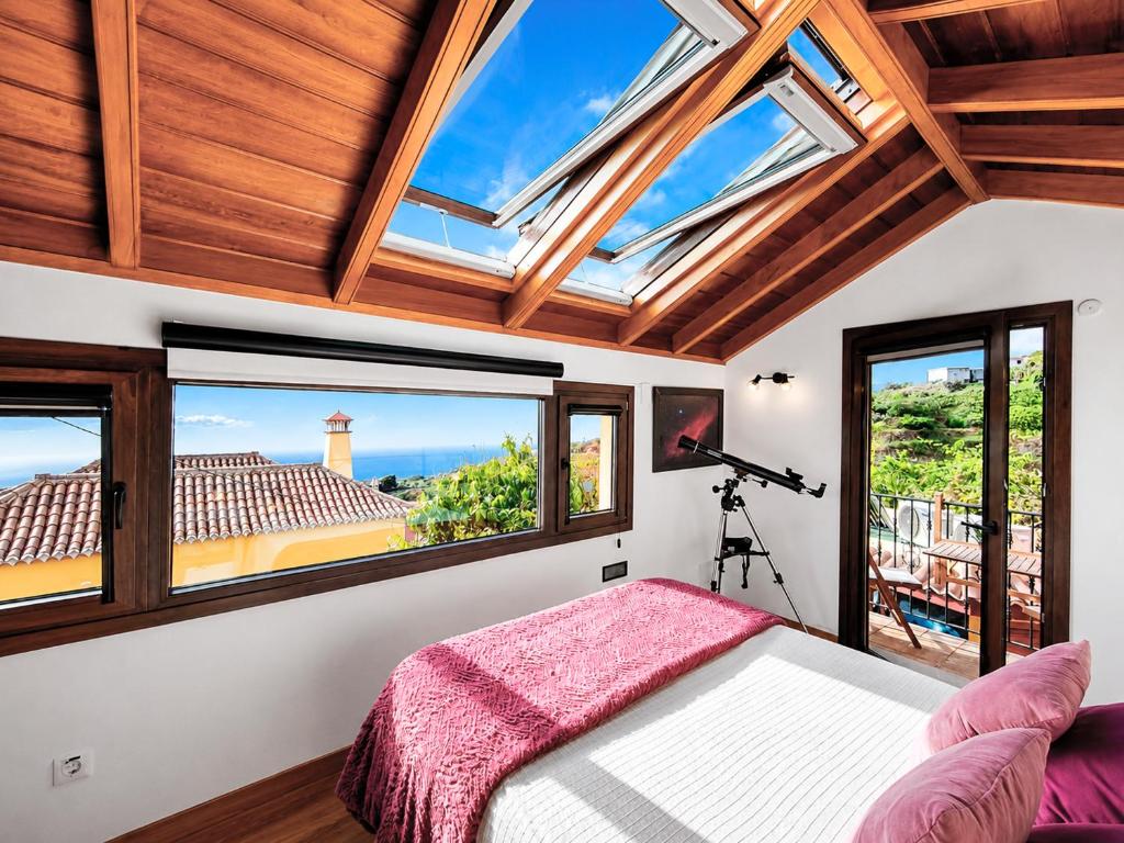 a bedroom with a bed and windows with a view at Los Nacientes Vega in Los Sauces