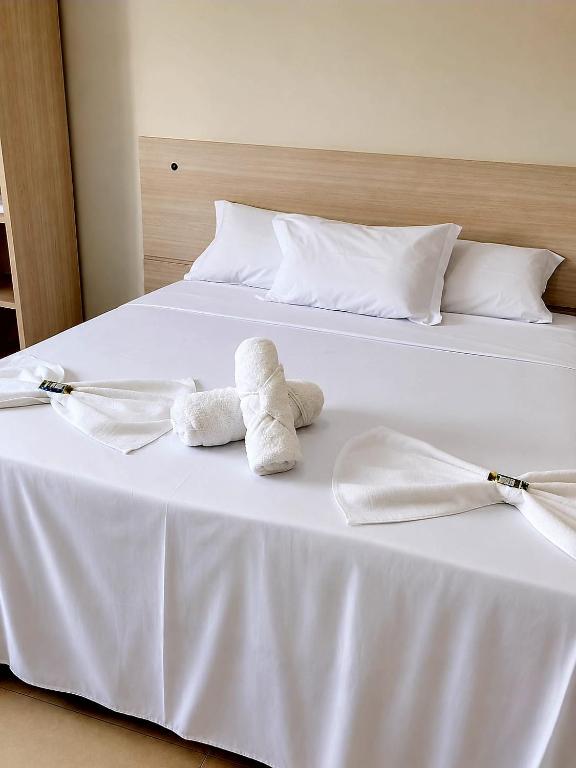 two stuffed animals sitting on top of a bed at Kuri Hotel in Padre Bernardo