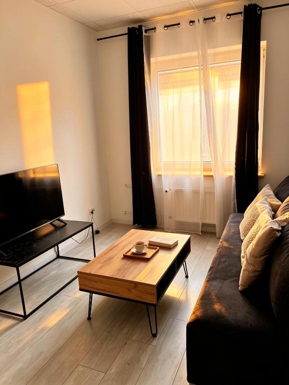 a living room with a couch and a coffee table at Nowoczesny Apartament Prudnik in Prudnik