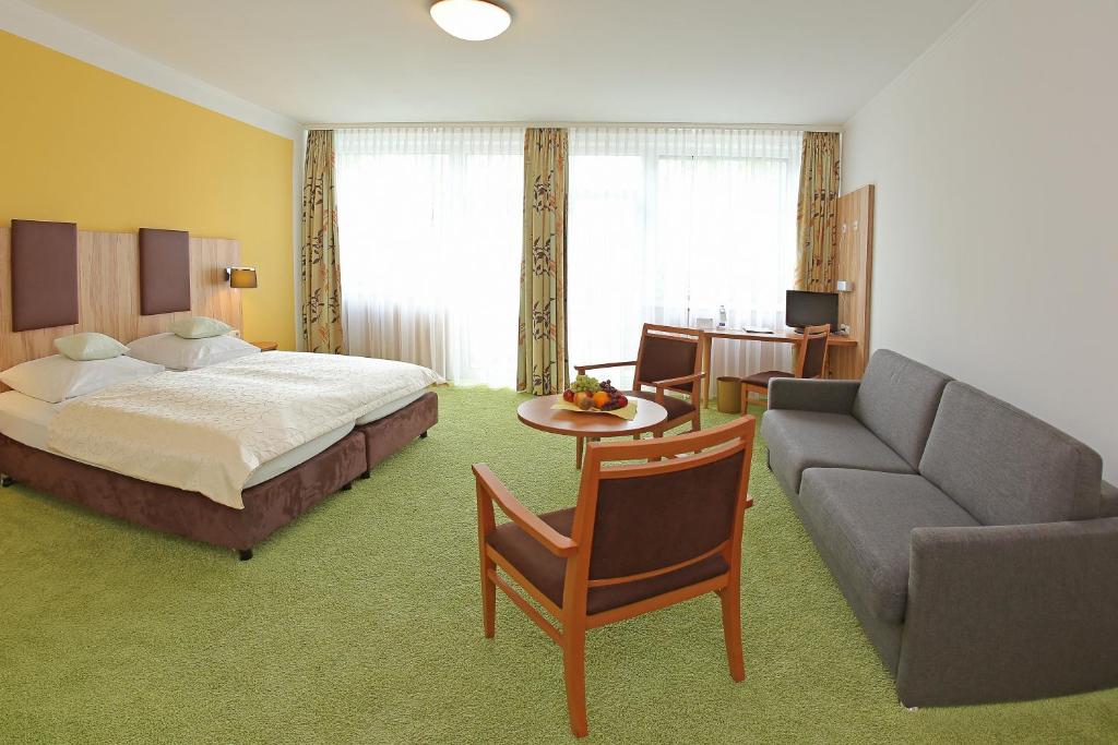 une chambre d'hôtel avec un lit et un canapé dans l'établissement Hotel Stadt Pasing, à Munich