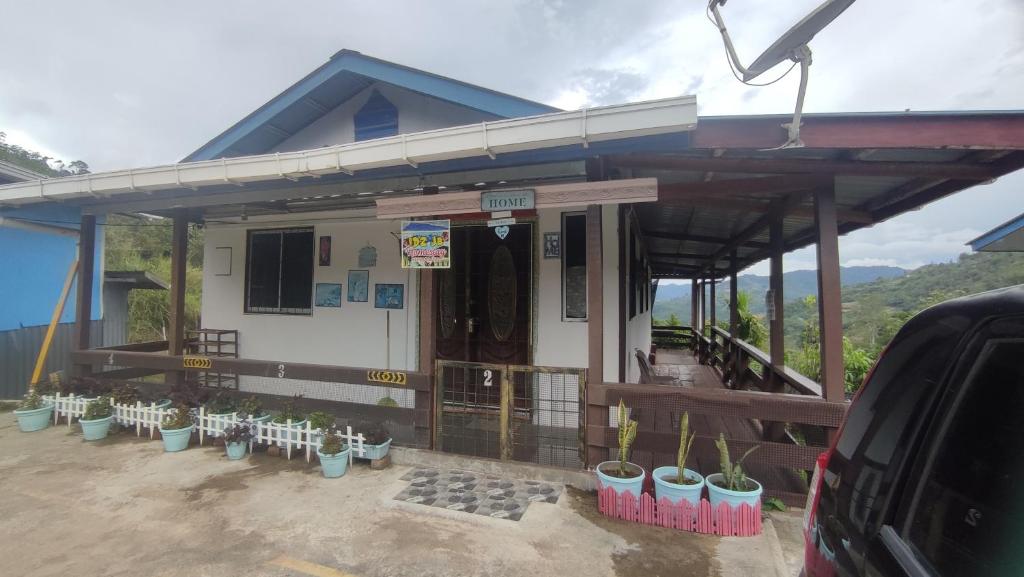 a house with potted plants in front of it at IDZ Jb ISLAM House in Kampong Kundassan