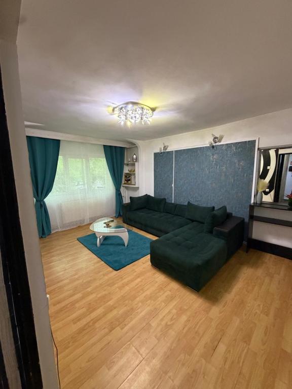a living room with a green couch and a table at Hypnotic Suite 1 in Piteşti