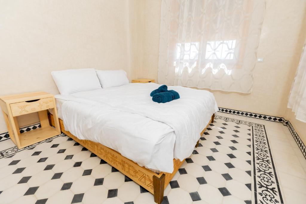a bedroom with a bed with a blue teddy bear on it at KASA GUEST Tamraght in Tamraght Ouzdar
