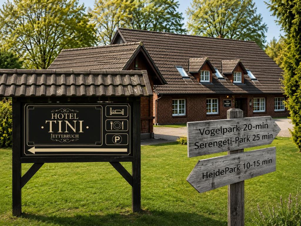 a sign in front of a house with a hotel sign at Hotel Tini in Bad Fallingbostel
