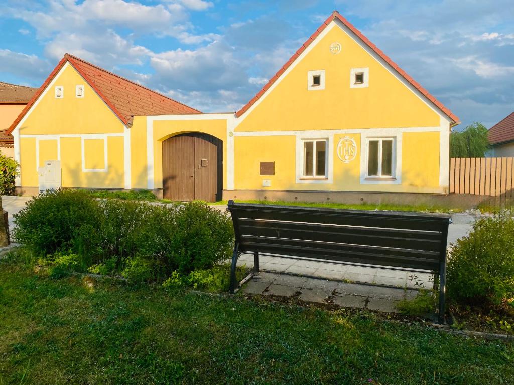 a bench in front of a yellow house at Škorničkův statek - chalupa Andělka s wellness za příplatek in Hamr
