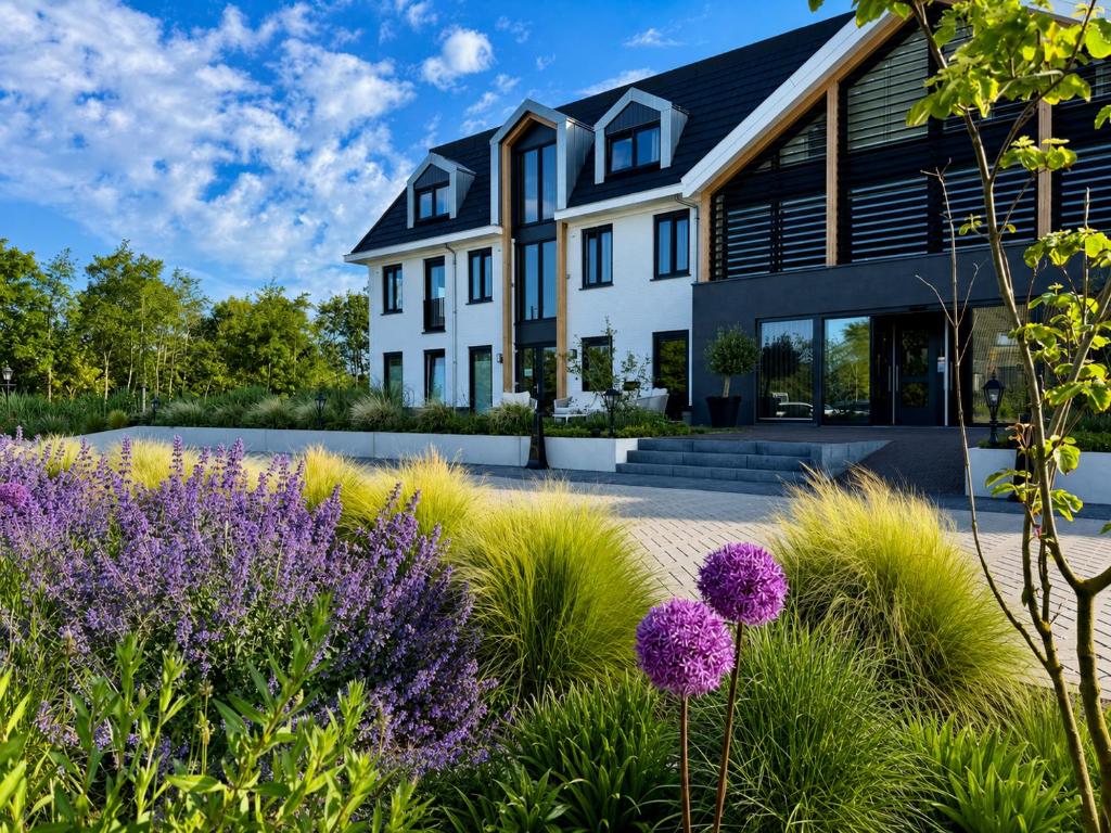 a house with a garden with purple flowers at Eilandhotel Texel - Nieuw geopend hotel in De Cocksdorp