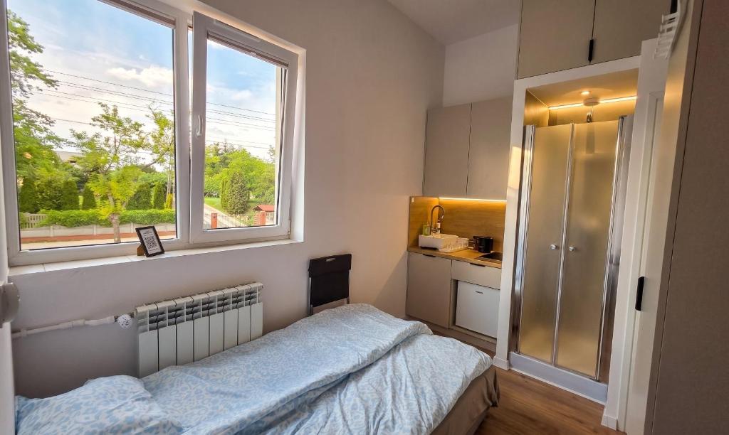a small bedroom with a bed and a window at Mini nocleg przy dworcu in Tomaszów Mazowiecki
