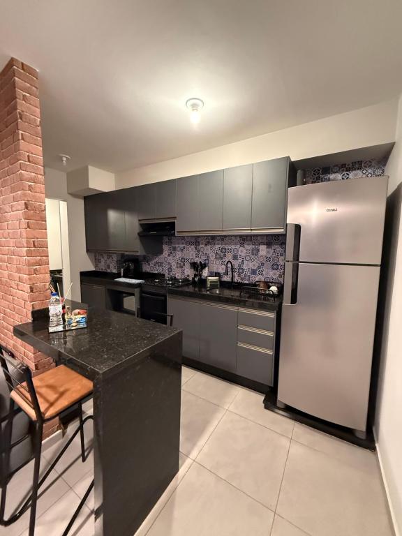 a kitchen with a stainless steel refrigerator and a counter at Apartamento Parque Trianon Exclusive in Araçatuba