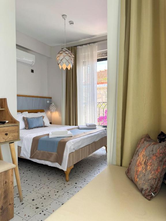 a bedroom with a large bed and a window at Wind Alasata in Çeşme