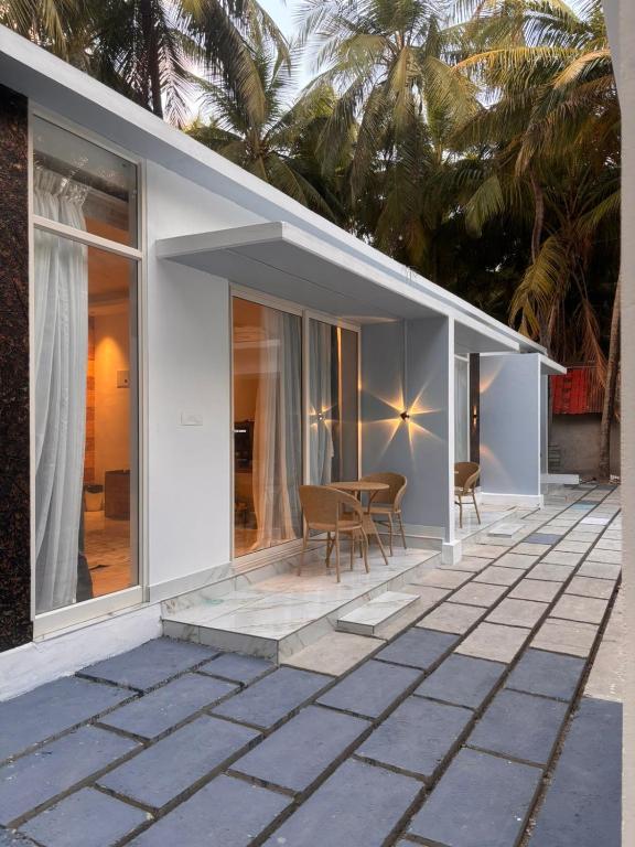 a white house with a table and chairs on a patio at Beachside Agatti Resort in Agatti