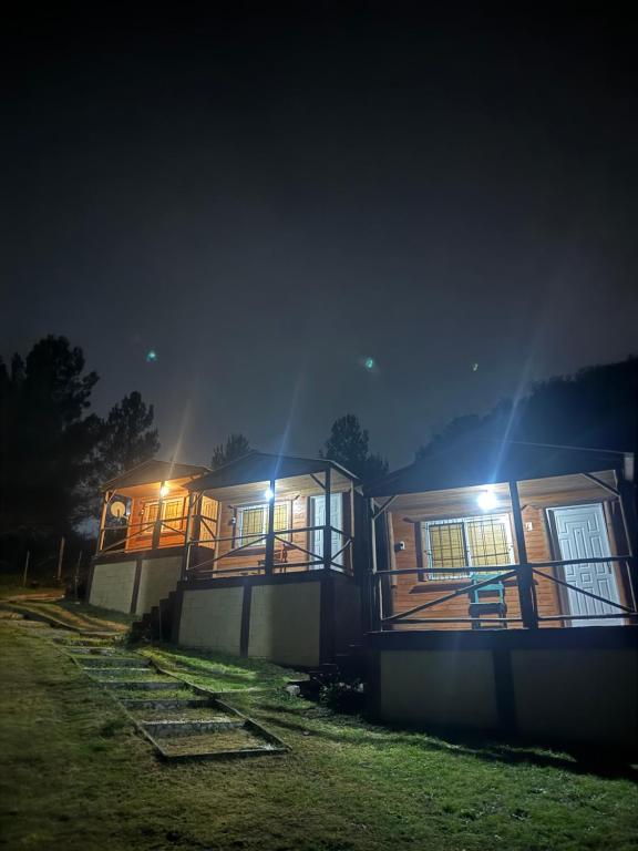a row of houses at night with lights at Cabañas las fulanas in Villa Giardino