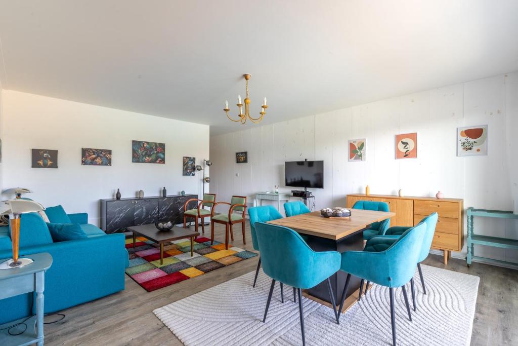 a living room with a blue couch and a table at Green Flat - Appt proche des Sables dOlonnes in LʼAiguillon-sur-Vie