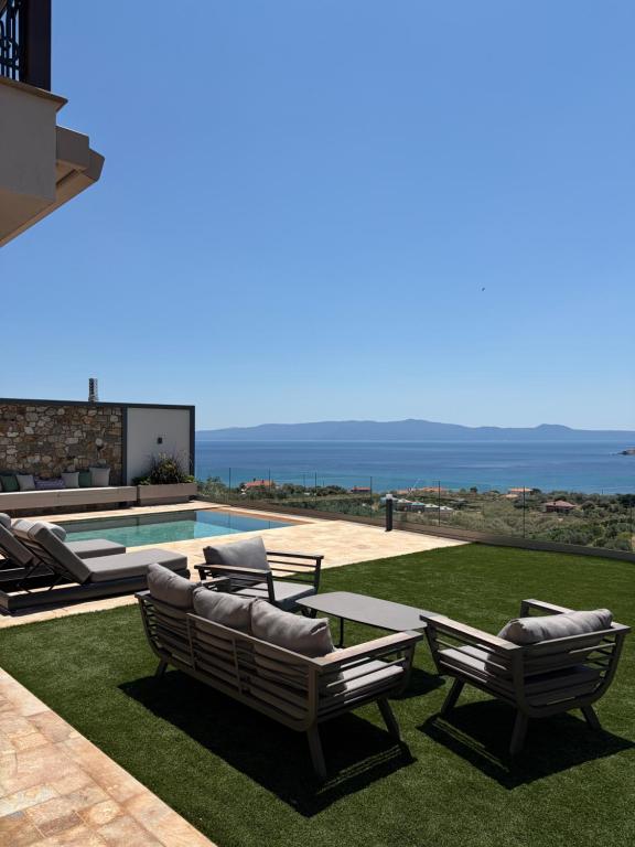 a patio with lounge chairs and a swimming pool at Elia Luxury House in Ouranoupoli