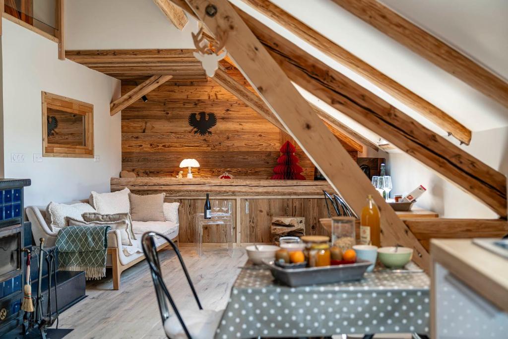 a kitchen and living room with wooden ceilings and a table at Cabane Malou - Avec jardin et à 200 m des pistes in La Salle-les-Alpes