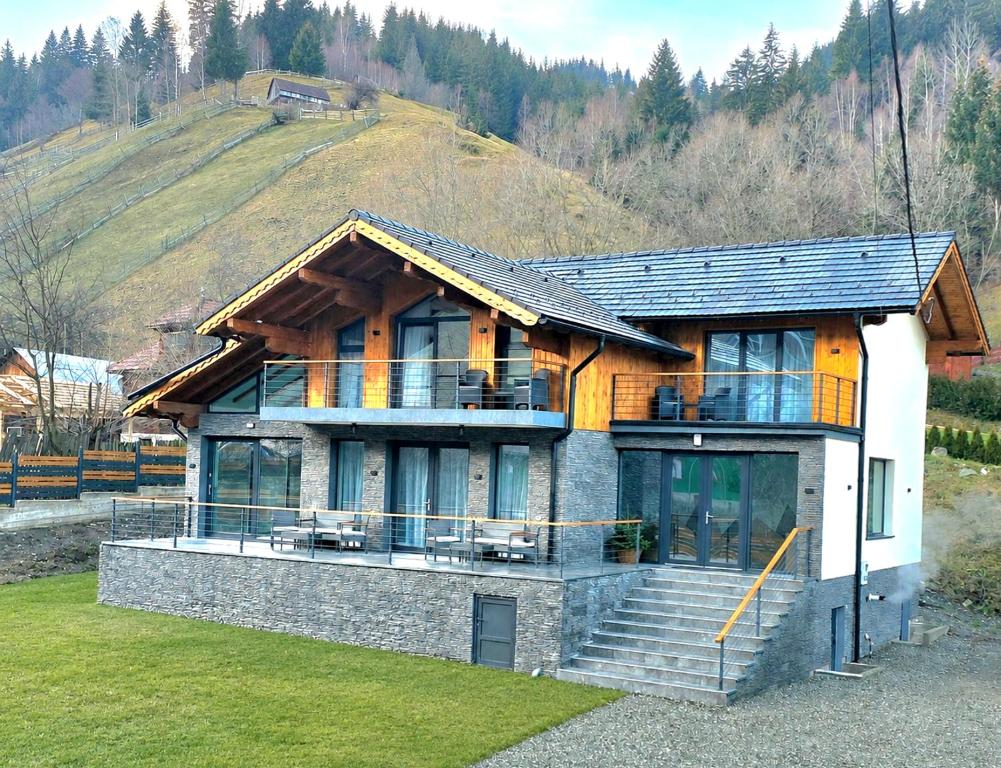 a house on a hill with a staircase in front of it at Wolf Chalet - Moieciu de Sus in Moieciu de Sus