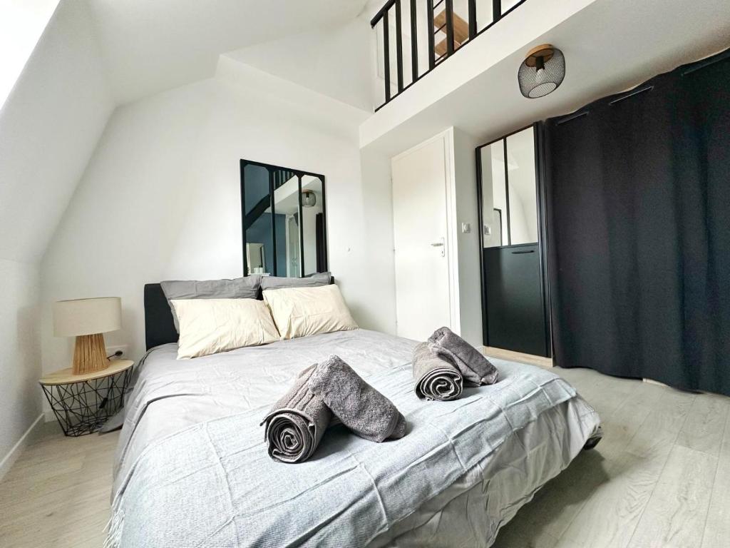 a bedroom with a large bed with two pillows on it at L'Échappée Croisienne in Croix