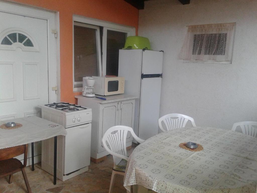 a kitchen with a table and a white refrigerator at Apartment Mirjana I in Šišan