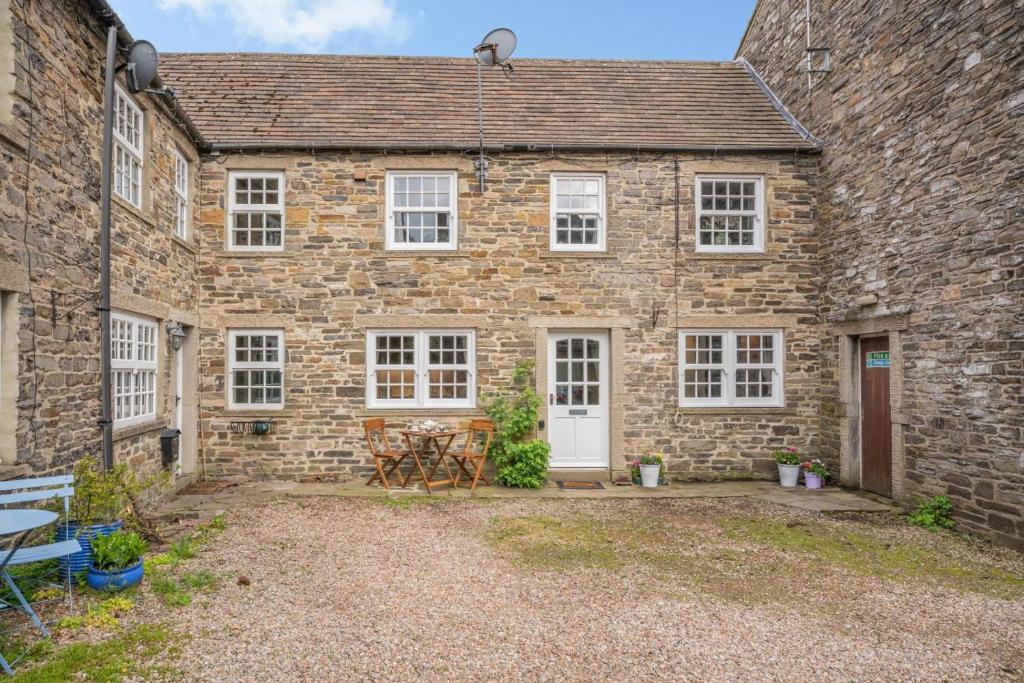 an old stone house with a table and chairs in front of it at 2 Bed in Leyburn oc-n41362 in Leyburn