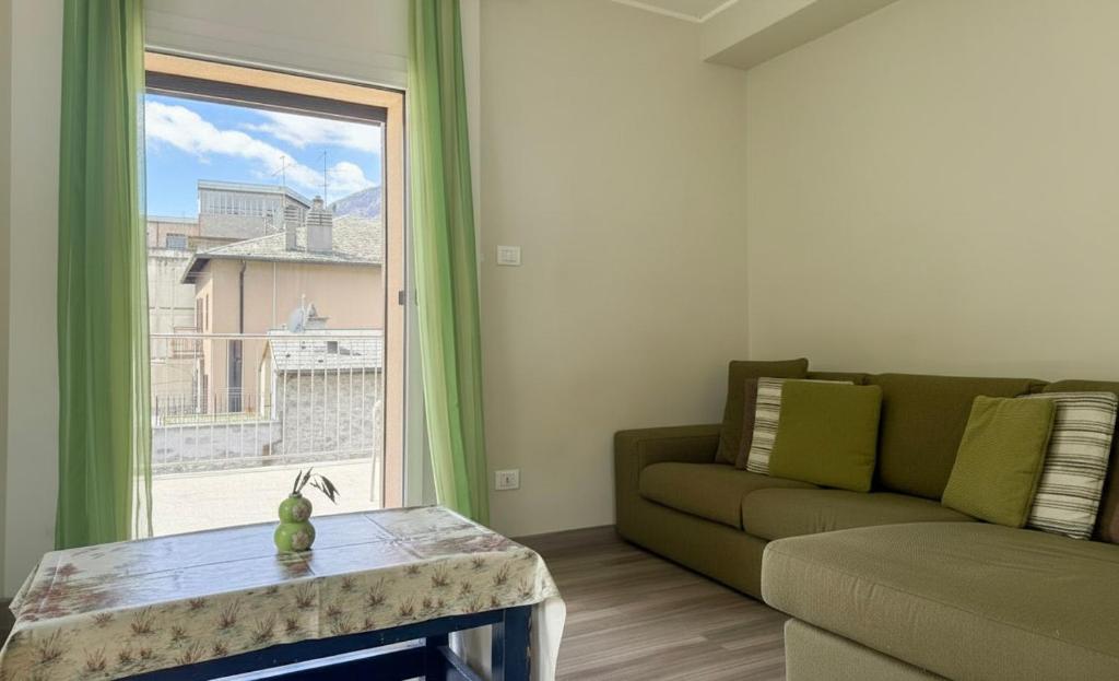 a living room with a couch and a large window at La Terrazza di Gino in Grosio