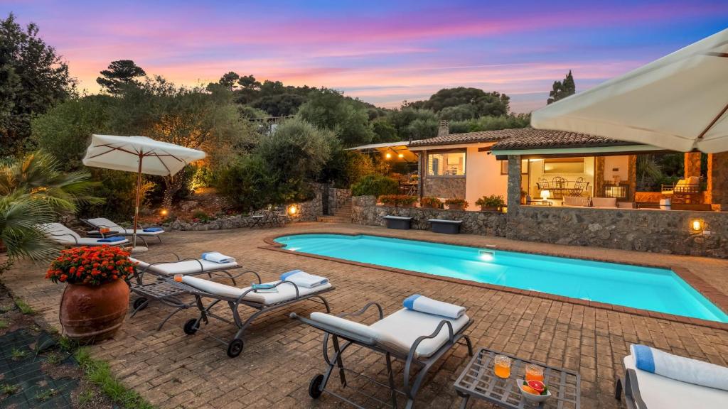 a swimming pool with chairs and a house at VILLA ALTHAEA 6, Emma Villas in Orbetello