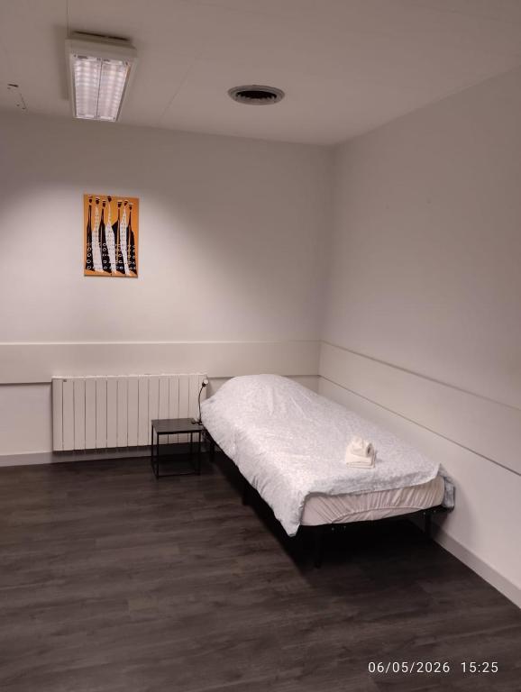 a white room with a bed in the corner at Le Lilas - 6 in Cherbourg en Cotentin