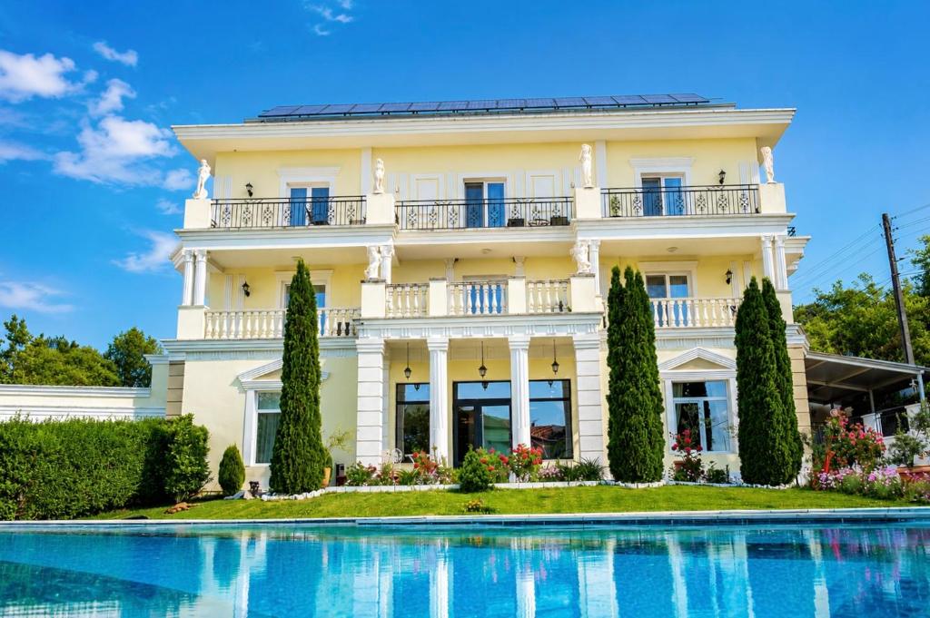 a large white house with a swimming pool in front of it at Aleksov Complex Aleksion Palace in Ognyanovo
