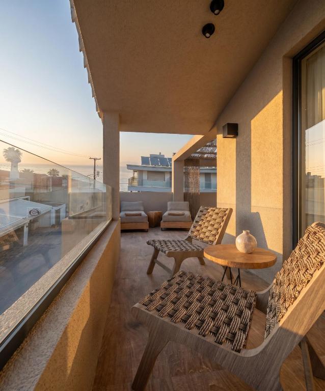 a balcony with a table and chairs on a building at D&C Premium Suites in Pefkochori