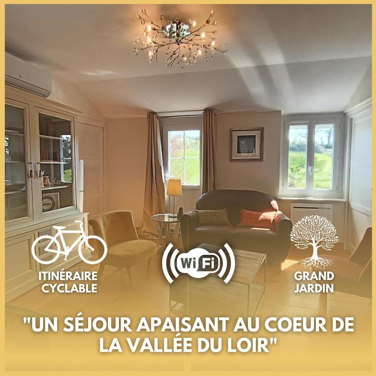 a living room with a couch and a bed and a chandelier at Le Cottage in Marçon