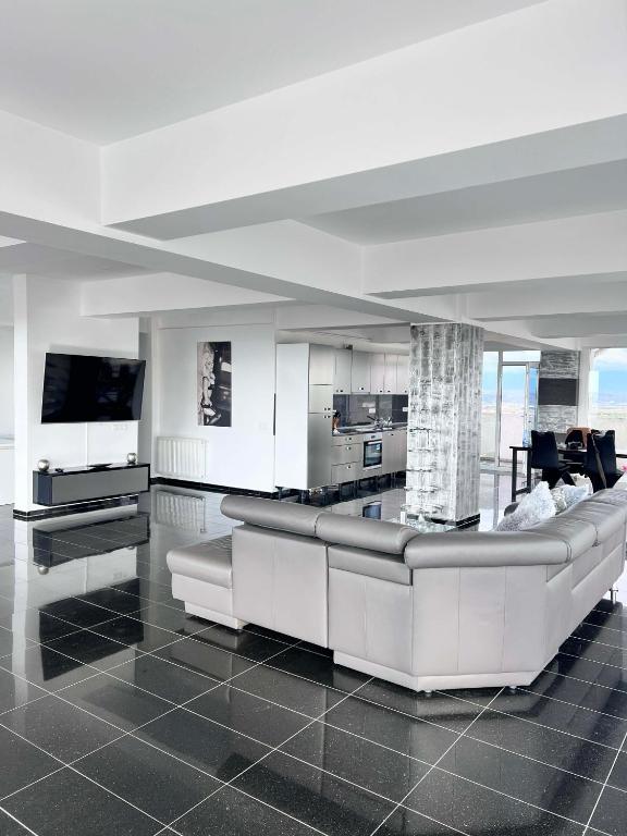 a living room with a white couch and a television at Rania Penthouse 2 in Şelimbăr