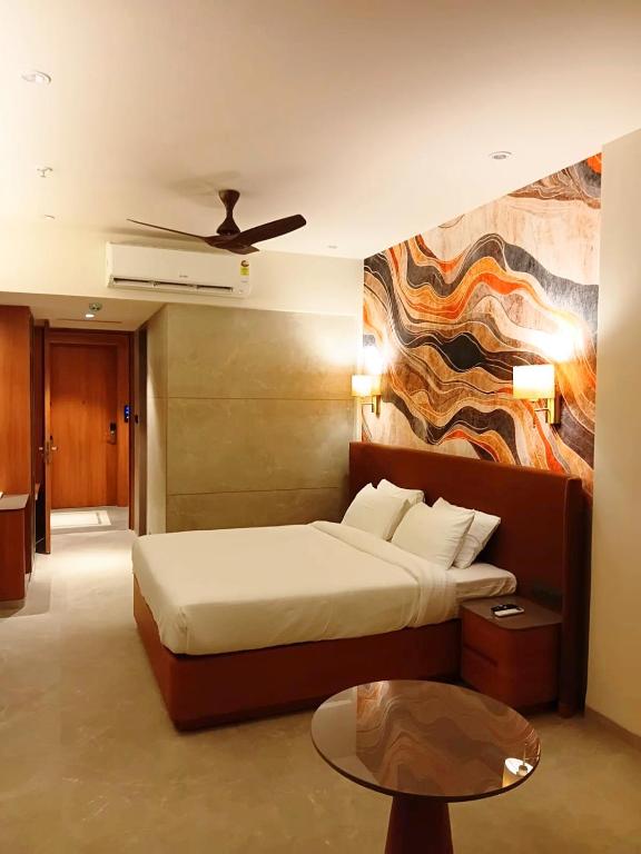 a hotel room with a bed and a table at Krishna Palace Hotel , Ulhasnagar in Ulhāsnagar