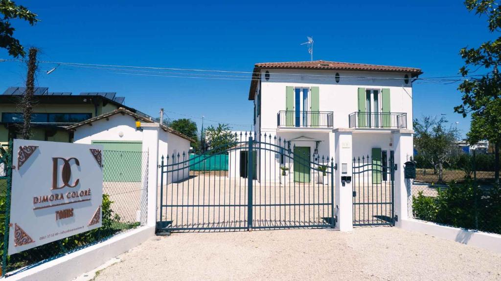 a white house with a gate in front of it at Dimora Coloré in Nereto