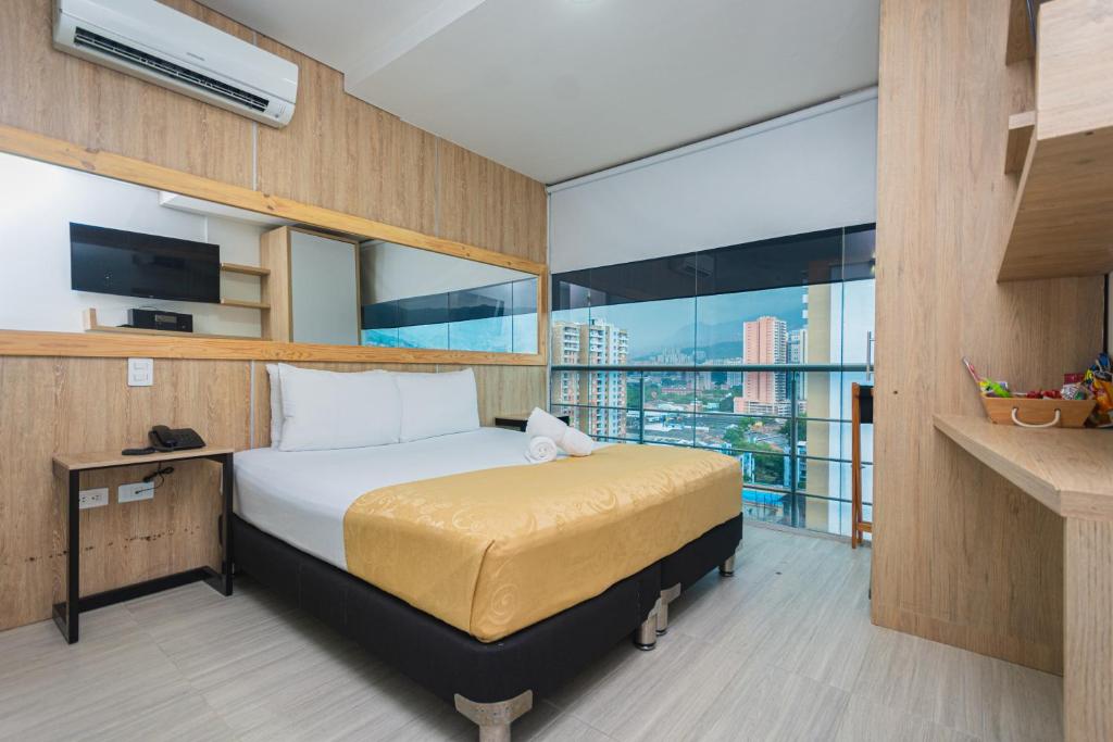 a bedroom with a bed and a large window at Hotel Piso 12 in Bello