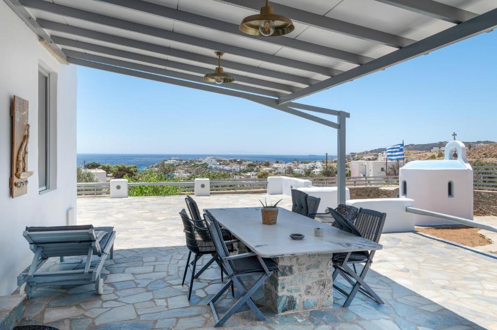 a patio with a table and chairs and a view at Villa Fotis in Ano Syros