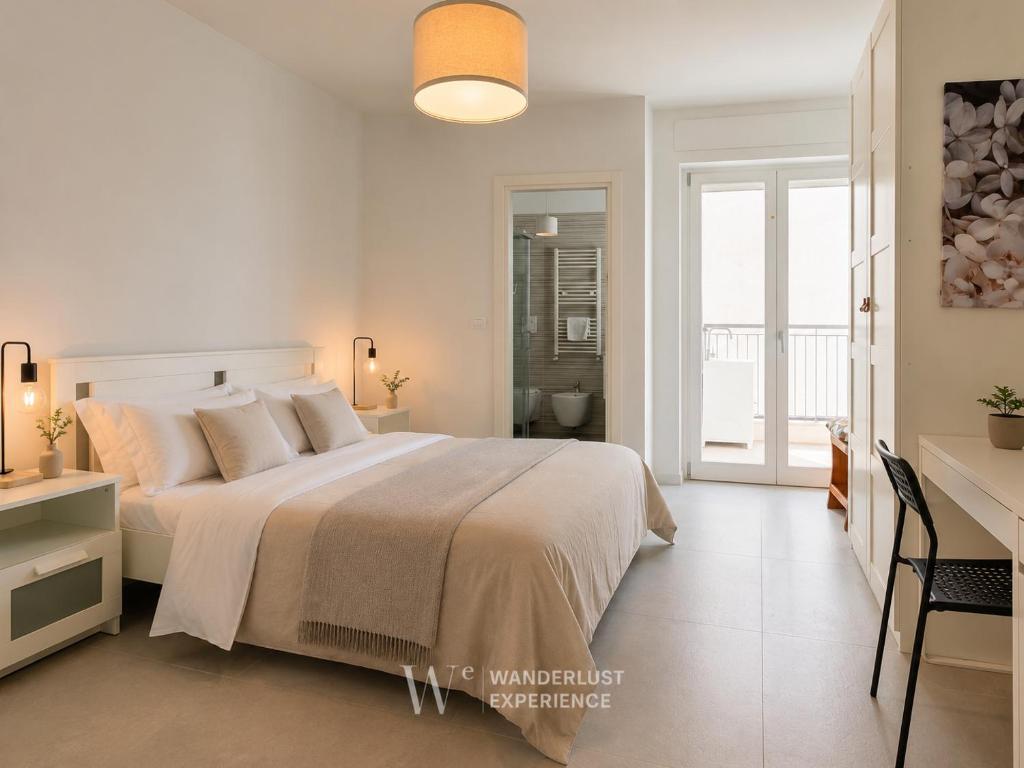 a white bedroom with a large bed and a bathroom at Wanderlust Experience Pumetta Apartment in Bitonto