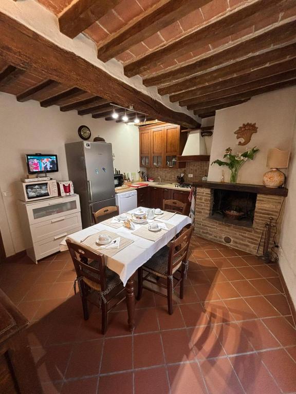 a kitchen with a table with chairs and a refrigerator at Casa Didi in Cetona
