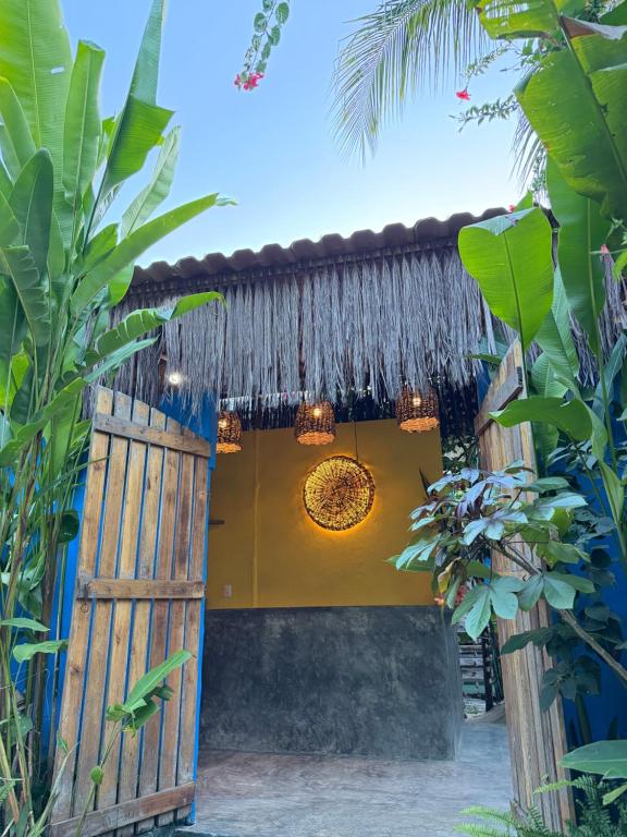 a view of a house with a thatch roof at Pousada Nascente do Sol in Ilha de Boipeba