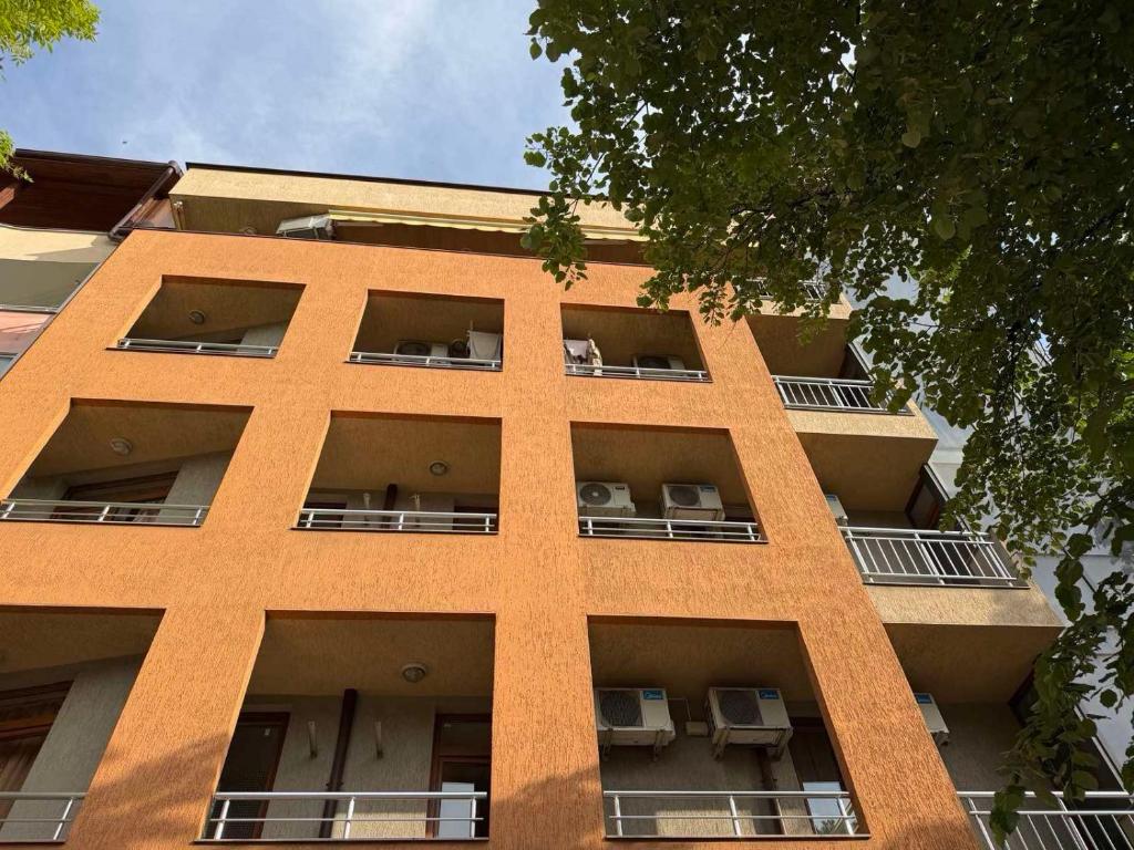 a tall orange building with chairs in the windows at Top Center House in Plovdiv