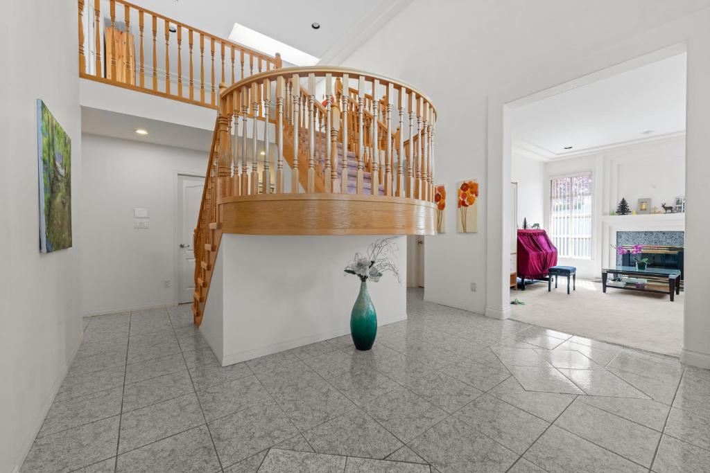 a living room with a staircase and a vase with flowers at Home Base Quiet Queen Rooms in Richmond