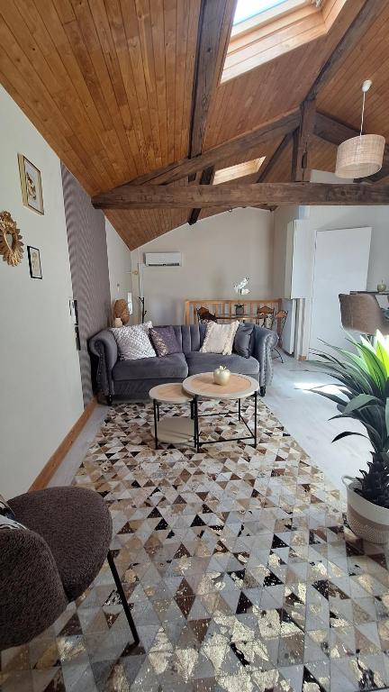a living room with a couch and a table at La tête dans les étoiles - Appartement climatisé - 2 Chambres in Ruffec
