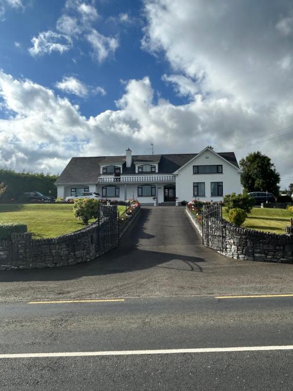 a large white house with a gate on a road at Seawater View Accomadation - Accommodation only in Red Castle