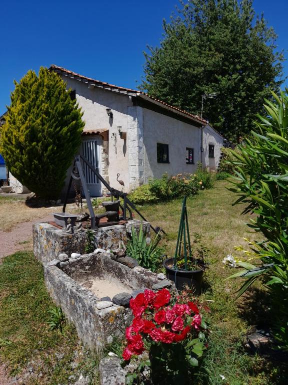 an old house with flowers in front of it at Maison Vacances in Saint-Savinien