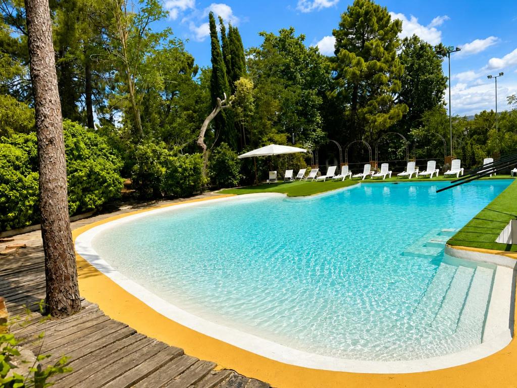 a large swimming pool with lounge chairs and trees at Hotel Rural Victoria by Bossh! Hotels in Cuenca