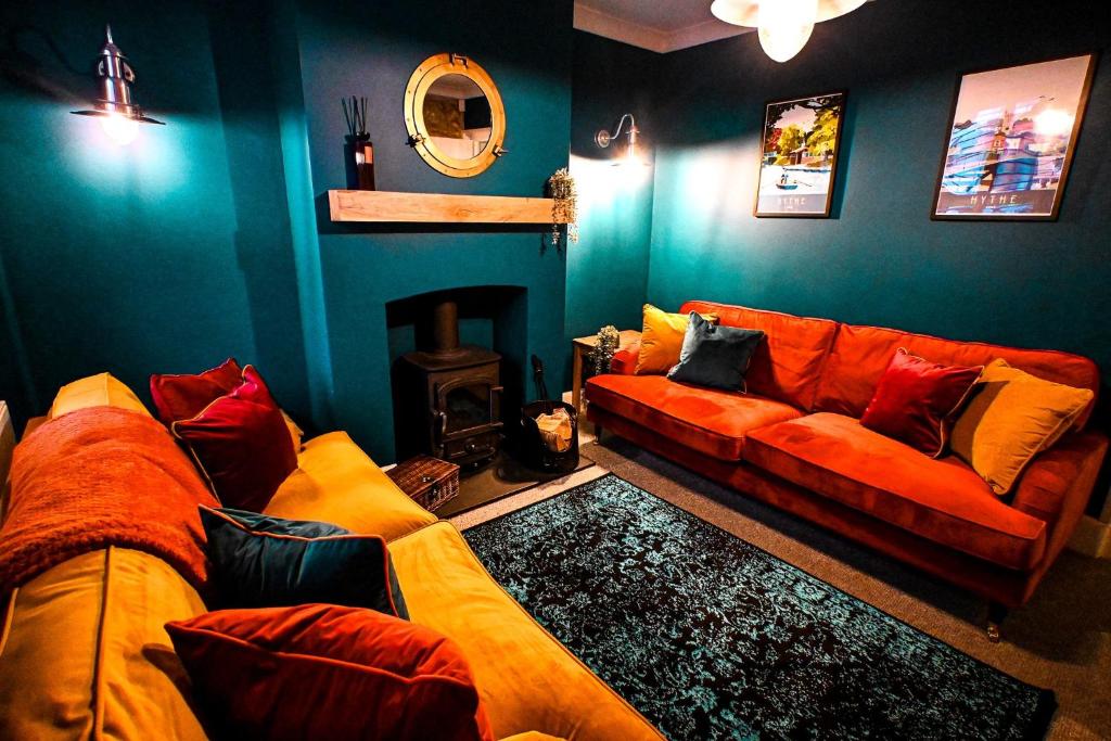 a living room with a couch and a fireplace at Stade Cottage in Hythe