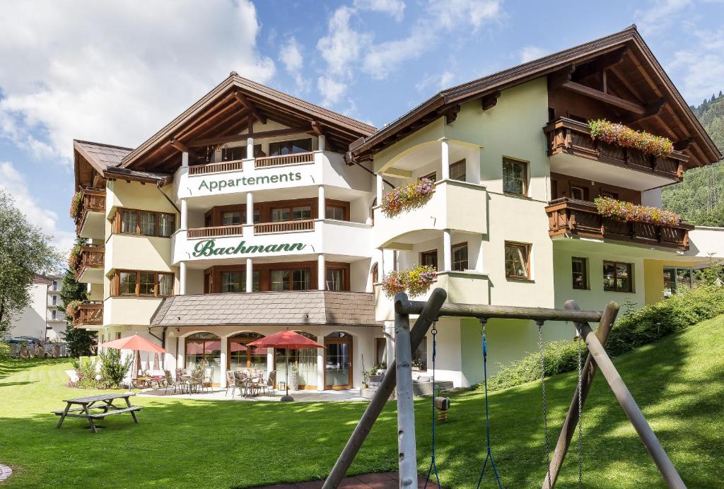 a hotel in the mountains with a green lawn at Bachmann Appartements in Sankt Anton am Arlberg
