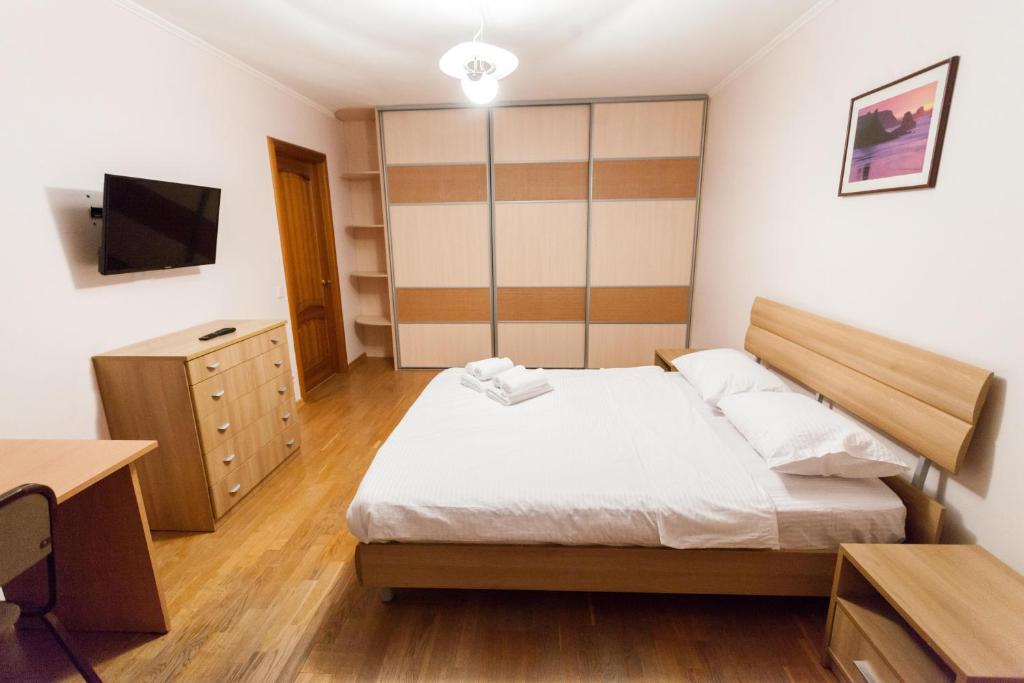 チュメニにあるApartment on Energetikov 53/3のベッドルーム(ベッド1台、デスク、テレビ付)