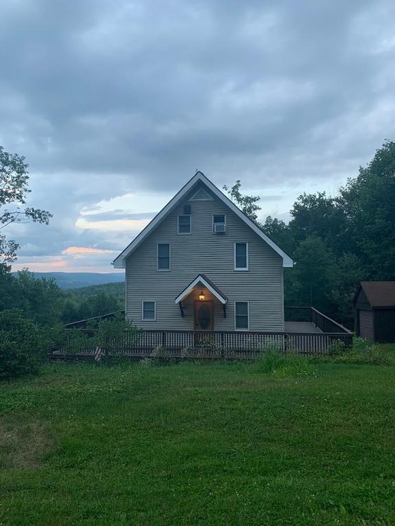 a large white house with a porch with a light on it at Private with a Beautiful View House in Afton
