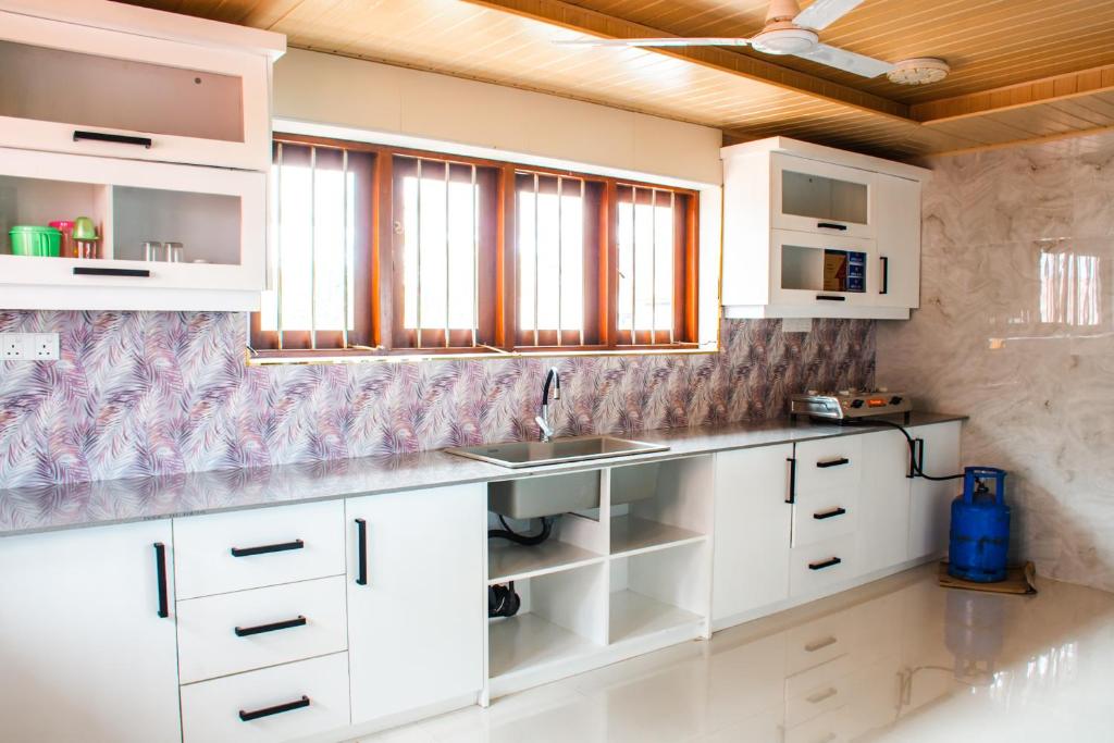 a kitchen with white cabinets and a sink at Villa Hima Arana in Galle
